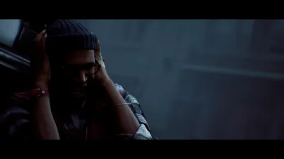 Townfall protagonist sitting with headphones, hands pressed to his head